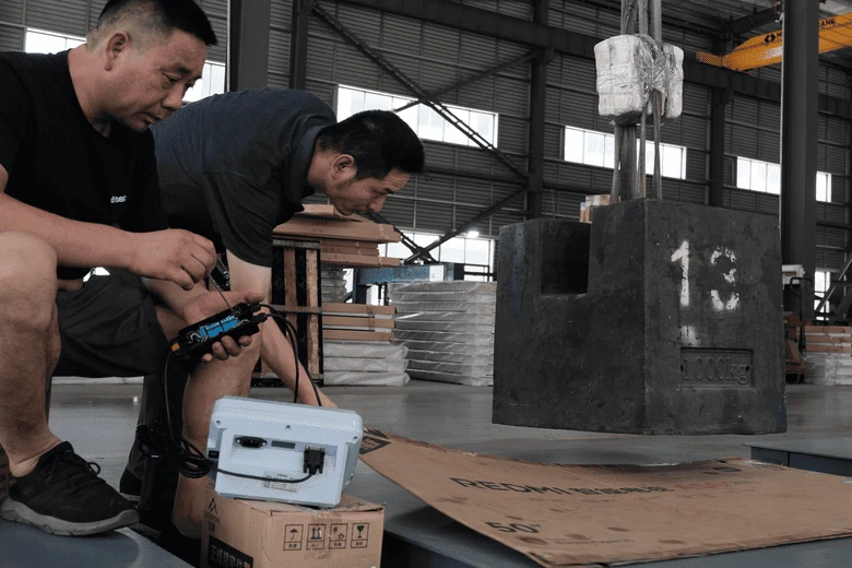 HENER staff adjusting a platform scale and indicator with a test weight