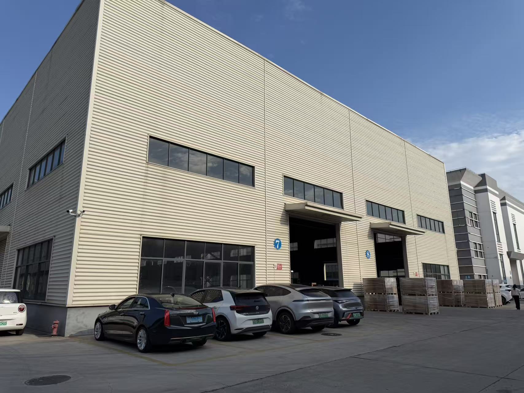 Exterior of the HENER factory, with workshop bays and loading areas