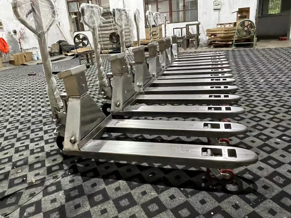 Rows of stainless-finish HENER weighing pallet trucks
