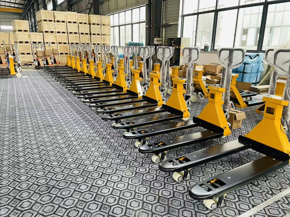 Rows of yellow and black pallet jack scales on the HENER workshop floor