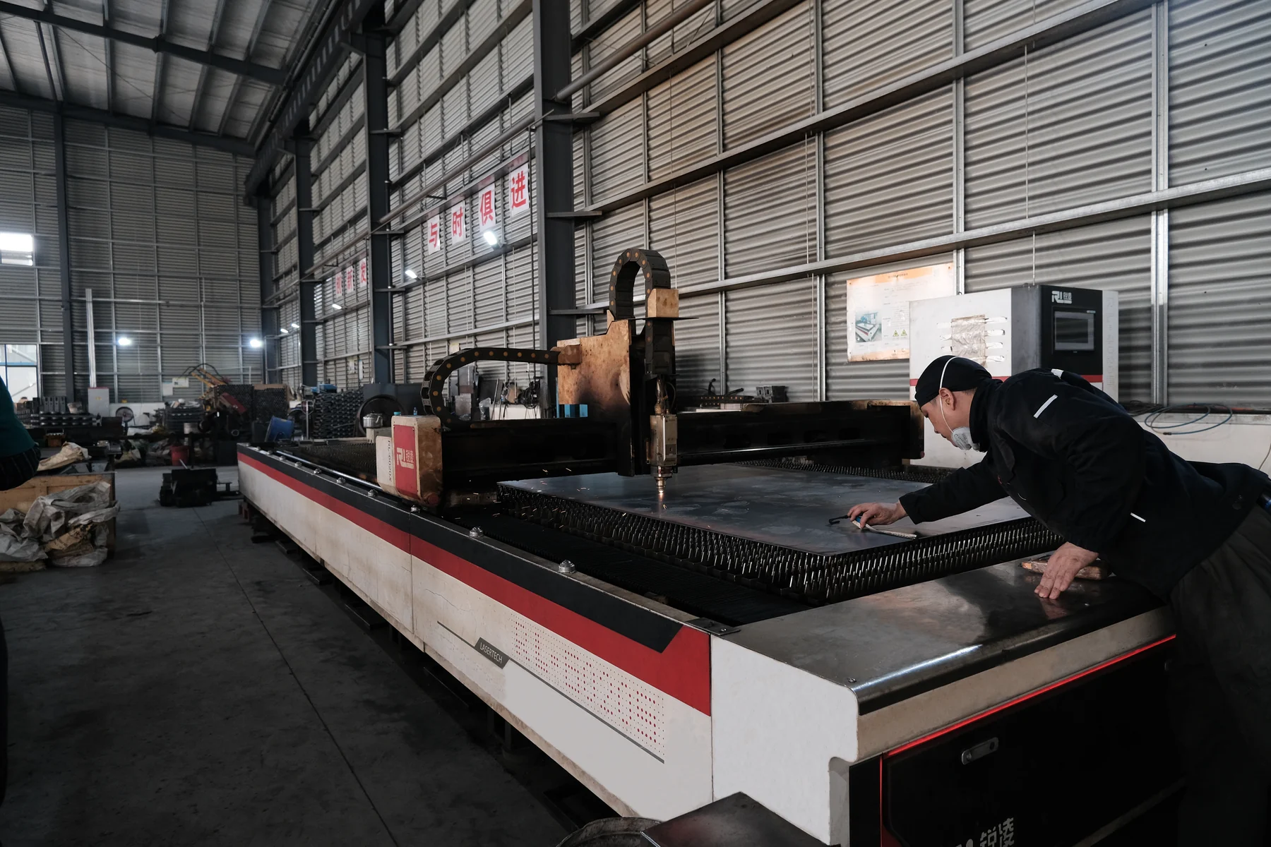 HENER factory worker preparing steel plate on a cutting machine