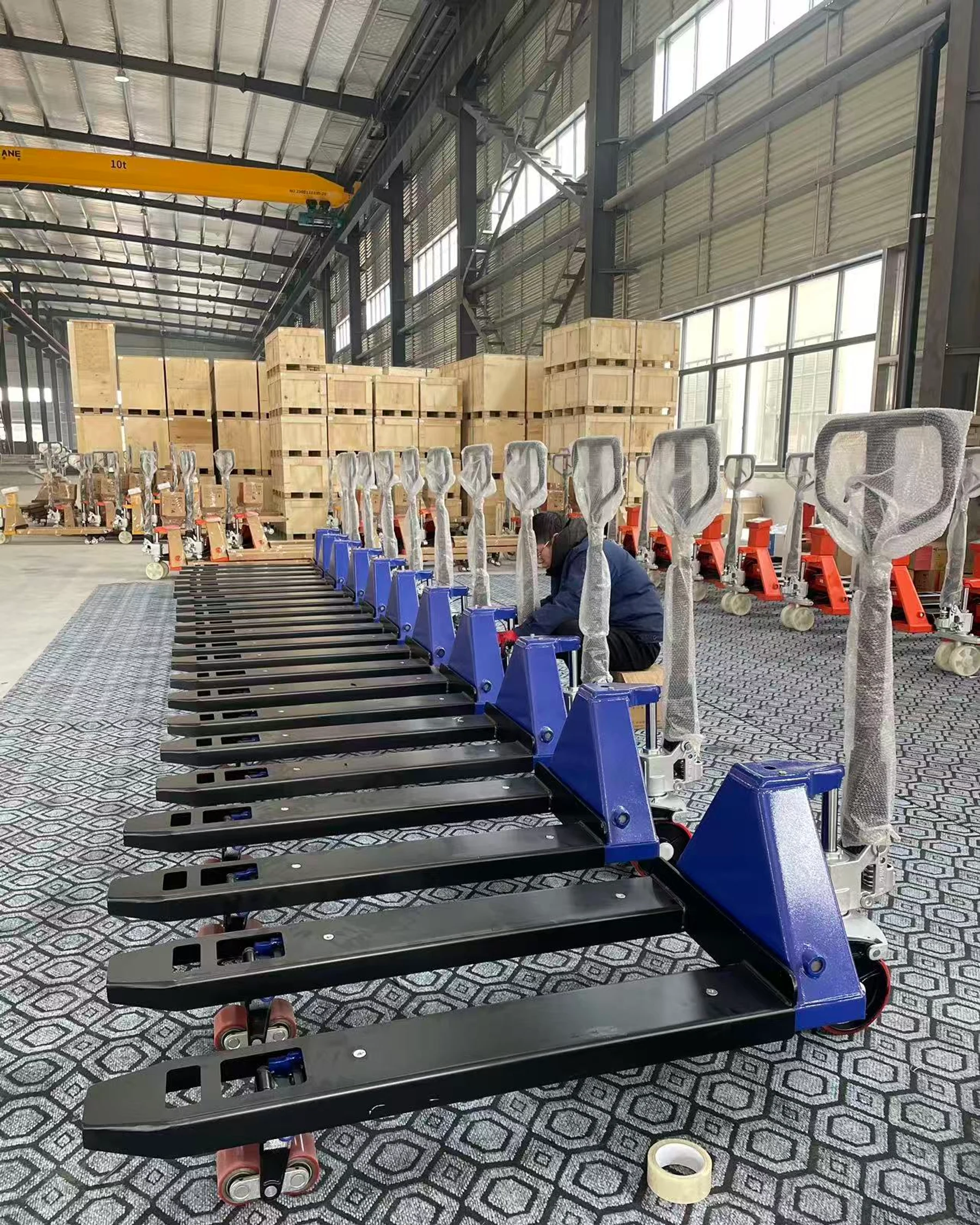Authentic HENER factory assembly area with pallet jack scales and active assembly work