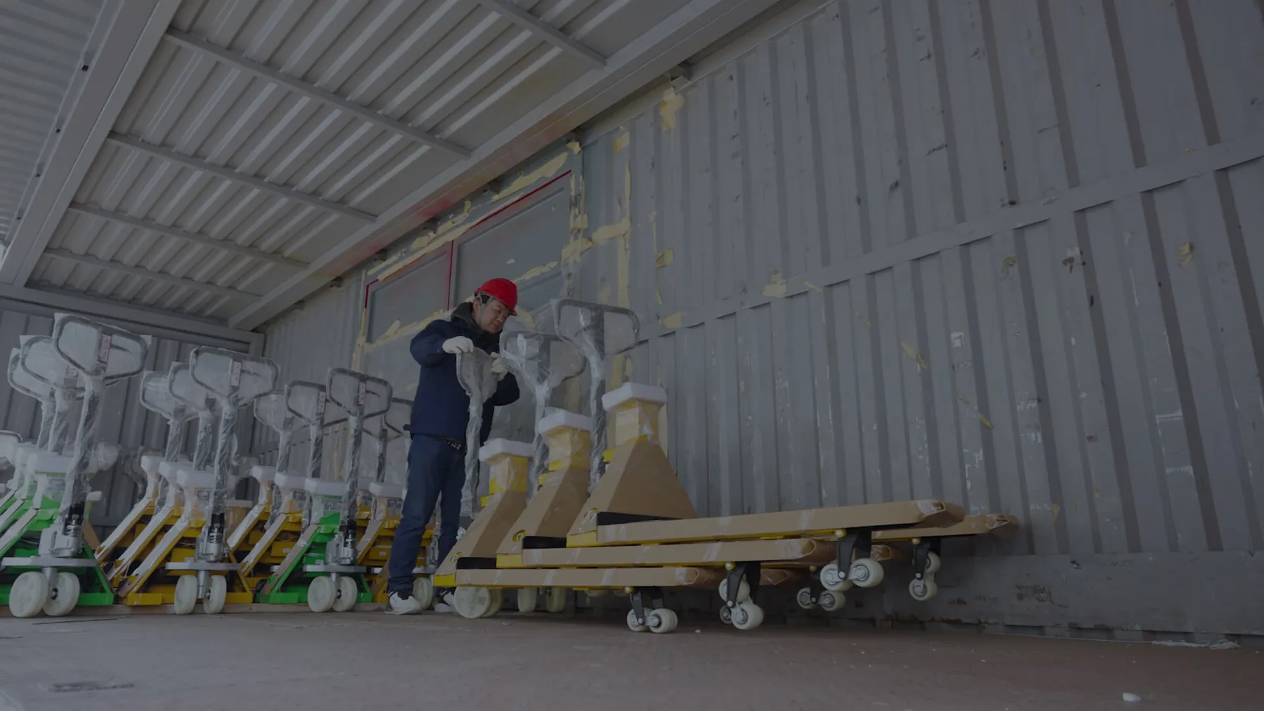 Wrapped manual pallet trucks arranged inside a shipping container